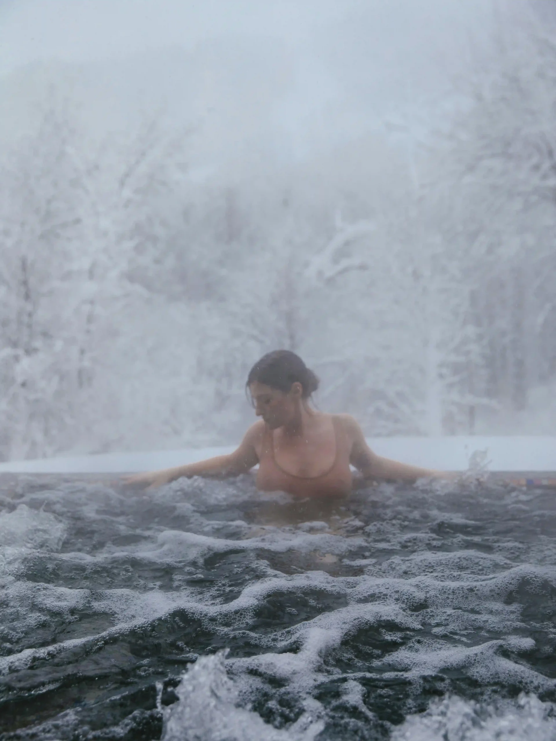 Spa extérieur dans un cadre enneigé, dégageant chaleur et relaxation.